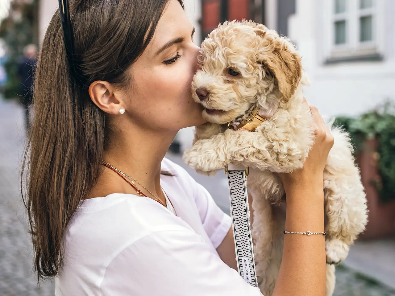Young woman kissing a puppy